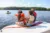 People sitting on a boat and tubing on an inland lake