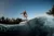 adult man riding on the wave with hydrofoil foilboard on background of blue sky
